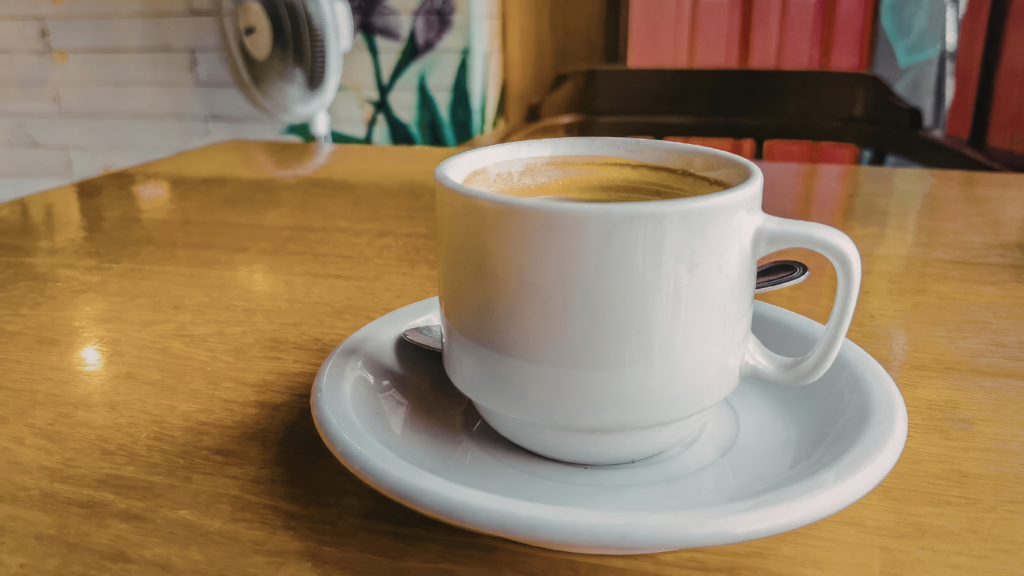 Café em grãos ao lado de café moído em pó, mostrando a diferença entre os dois tipos de café