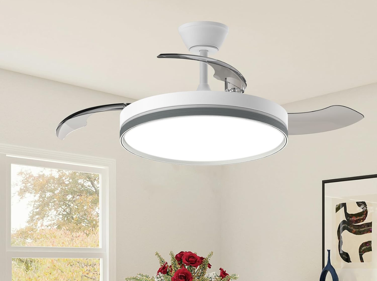 Ventilador de teto retrátil com luz LED redonda instalado em sala decorada com flores